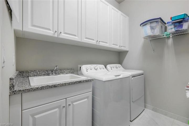 Laundry room offers plenty of additional storage AND a tub sink.