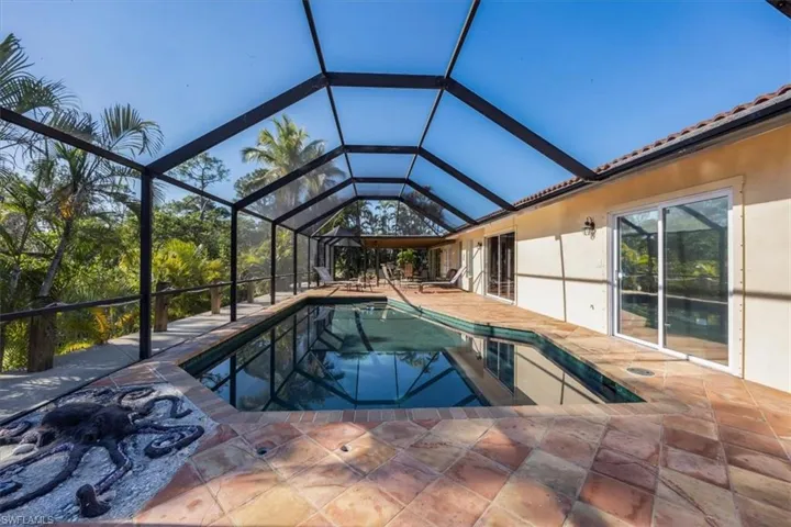 Outdoor pool with glass enclosure and a patio
