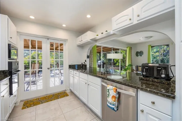 Kitchen with plenty of natural light, french doors, arched walkways, and appliances with stainless steel finishes