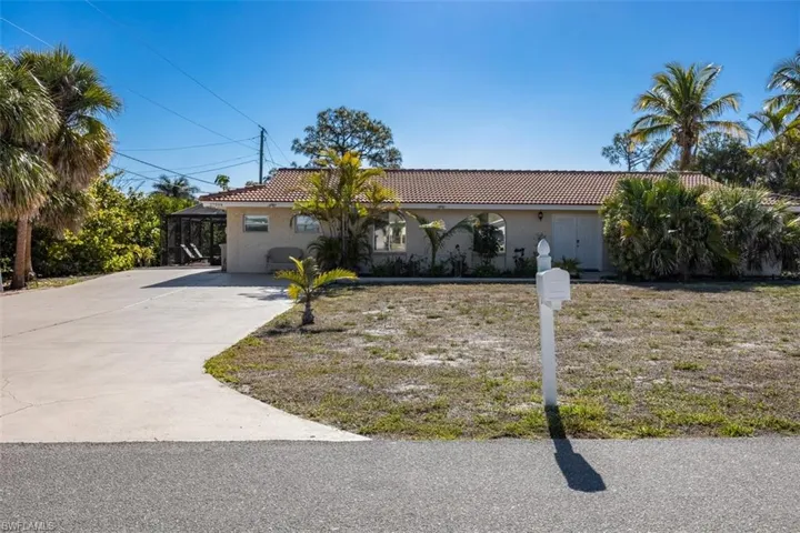 Ranch-style home featuring a tile roof, concrete driveway, and stucco siding