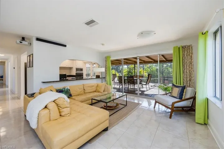 Living area with baseboards, visible vents, arched walkways, and marble finish floor