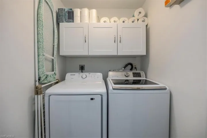 Clothes washing area with cabinet space and washer and clothes dryer