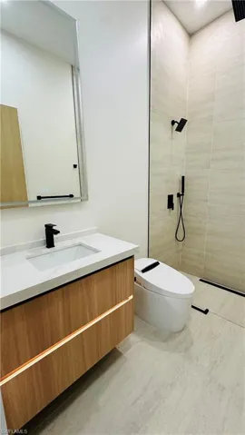Floating wood-finish vanity with an integrated sink, white countertop, and matte black faucet