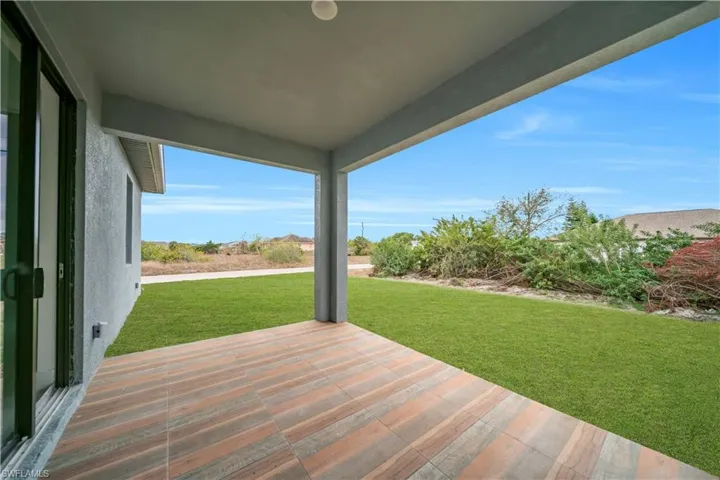 Wooden deck featuring a patio and a lawn