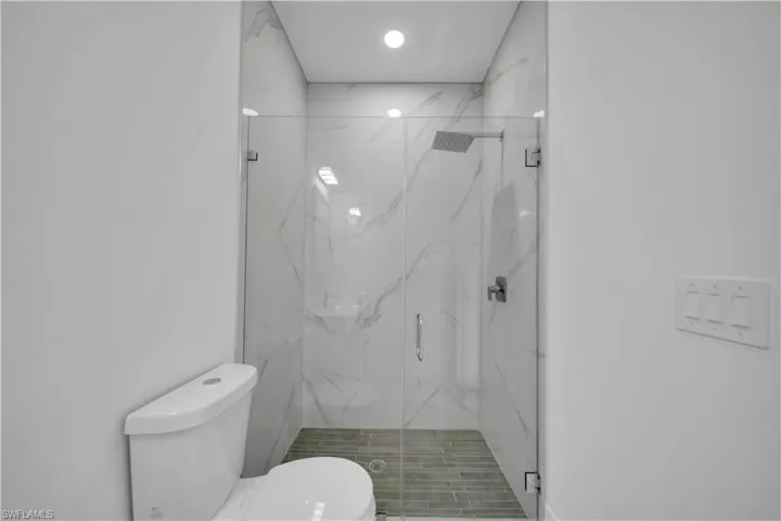 Full bath featuring a marble finish shower