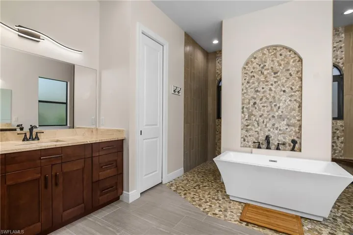 Custom tile work and designer lighting elevate the look of this primary bath.