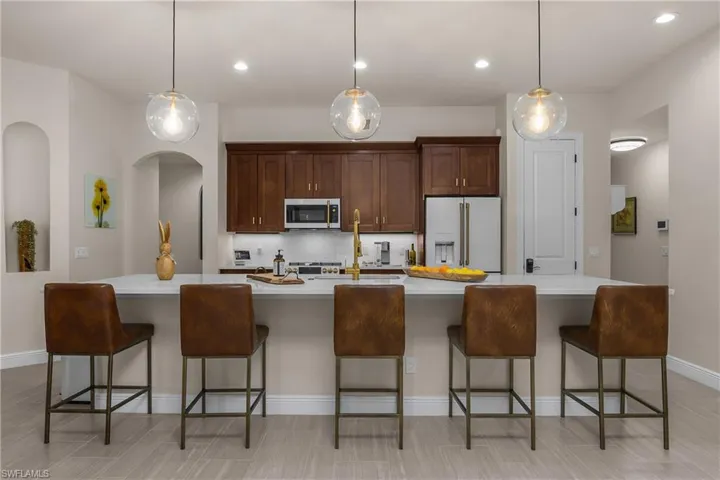 This spacious, upgraded kitchen features newer GE Cafe appliances, an oversized island, whole home reverse osmosis water system, custom backsplash, pull-out drawers in the cabinets, and a pantry for additional storage space.