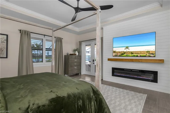 Double doors leading to screened lanai, and custom feature wall with remote fireplace.