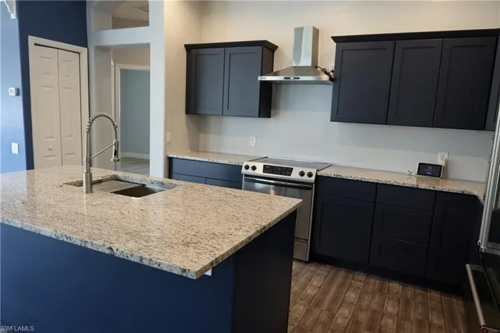 Kitchen featuring a spacious island with an undermount sink and gooseneck faucet