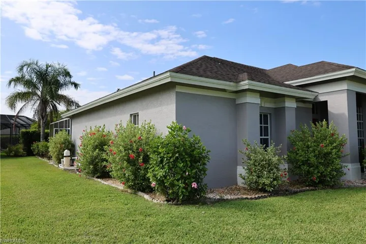 Exterior with gray stucco finish, dark shingle roof, and white trim