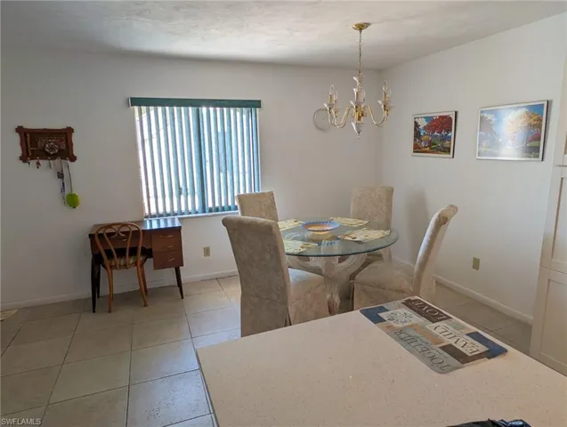 Dining area featuring light tile patterned floors and a chandelier
