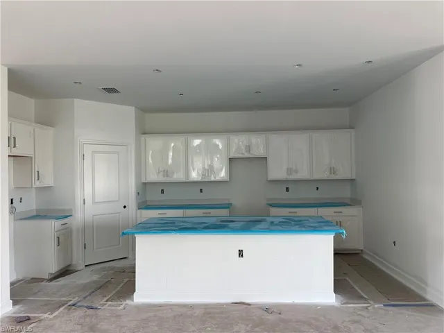 Kitchen with a center island and white cabinetry