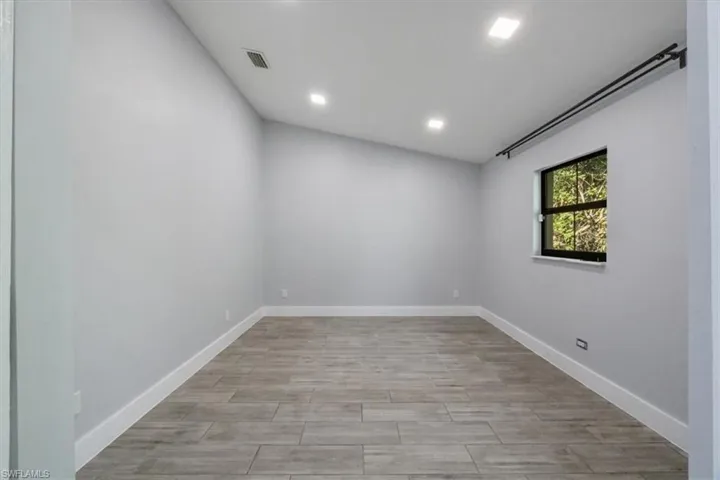 Spare room with wood finish floors and recessed lighting