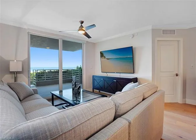 Living room , Gulf views with light wood flooring, ceiling fan, and ornamental molding
