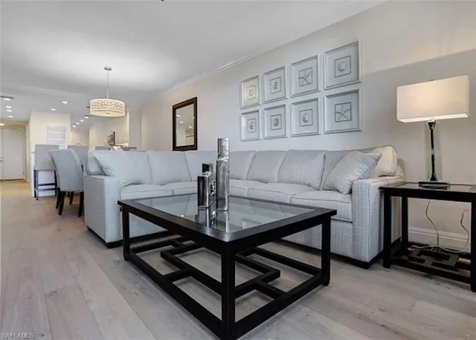 Living room featuring ornamental molding and light wood flooring