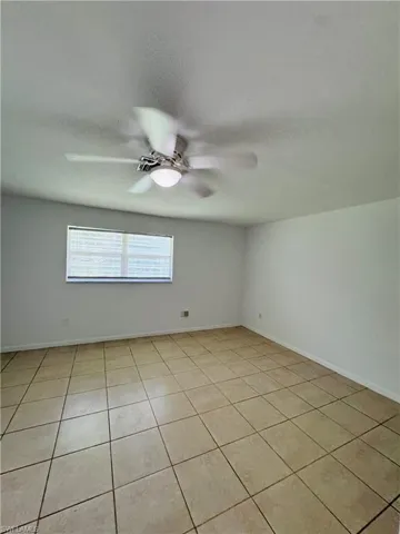 Empty room featuring light tile patterned floors, a textured ceiling, and ceiling fan