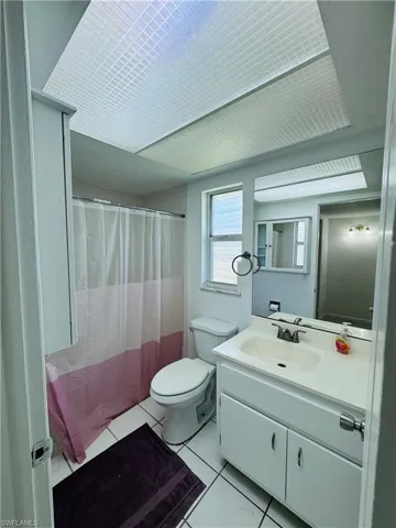 Bathroom featuring tile patterned flooring, toilet, and vanity