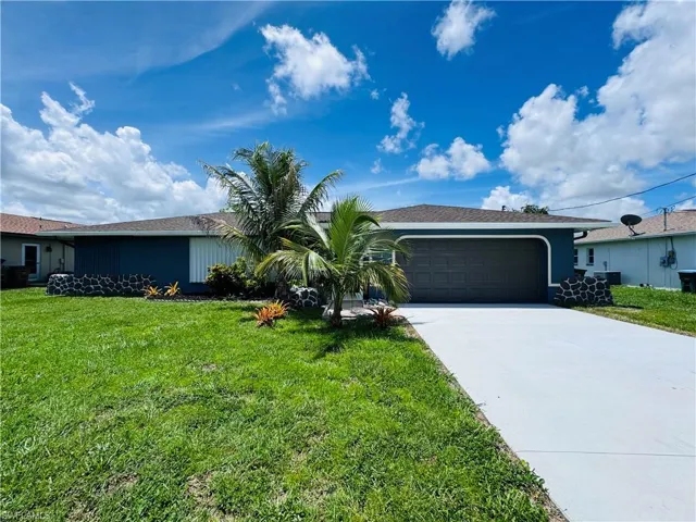 Ranch-style home with a garage and a front lawn