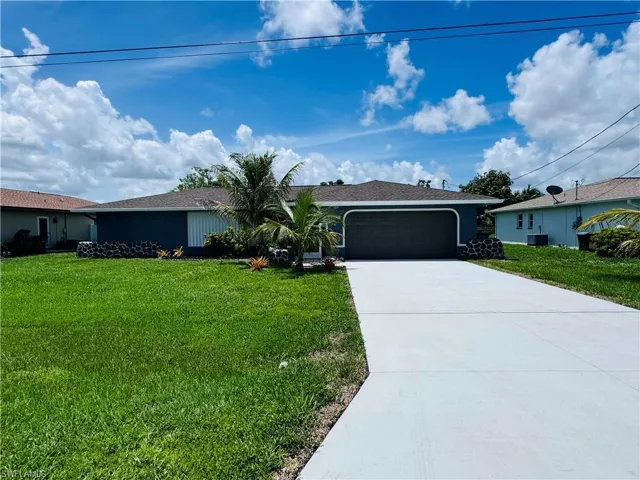 Ranch-style home featuring a garage and a front lawn