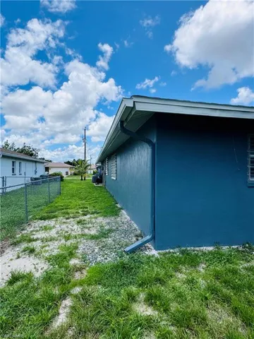 View of side of home featuring a yard