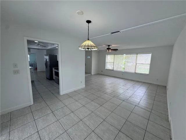 Unfurnished room with ceiling fan and light tile patterned floors
