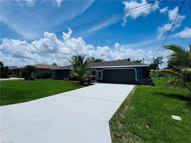 Single story home featuring a garage and a front lawn