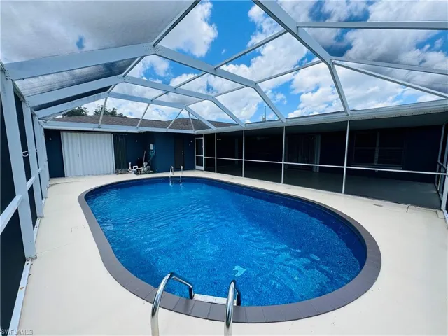 View of swimming pool with a patio and a lanai