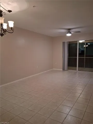 Empty room featuring hanging lights, a ceiling fan, and light tile patterned floors