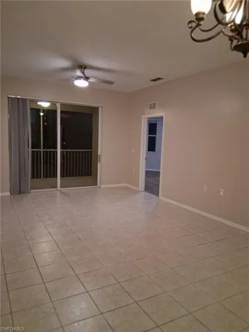 Empty room featuring hanging lights, a ceiling fan, and light tile patterned floors