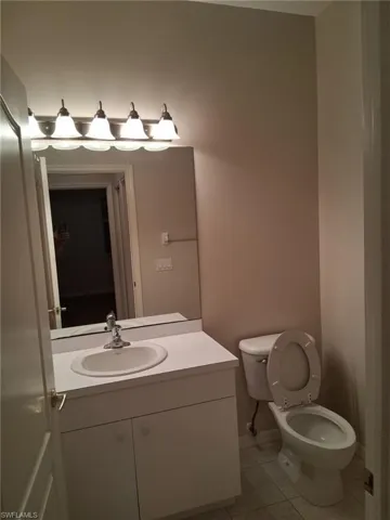 Half bath featuring vanity and light tile patterned floors