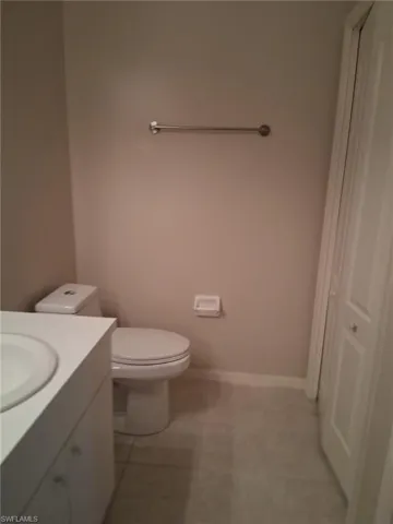 Half bath featuring vanity and light tile patterned floors