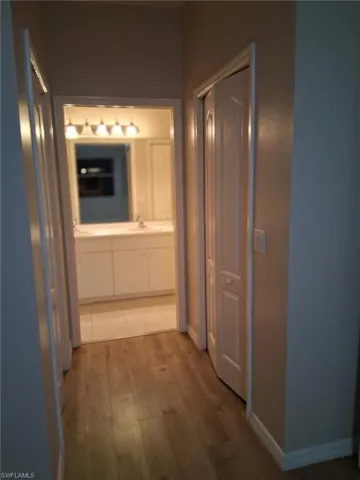 Hall with light wood-type flooring and baseboards