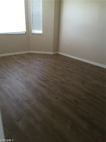 Unfurnished room with dark wood-style floors