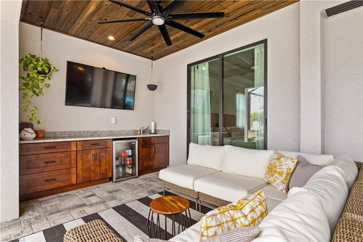 Lanai Seating Area under truss including built in cabinetry and granite counter with sink.