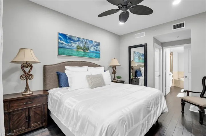 Bedroom with dark wood-type flooring, a ceiling fan, and ensuite bathroom