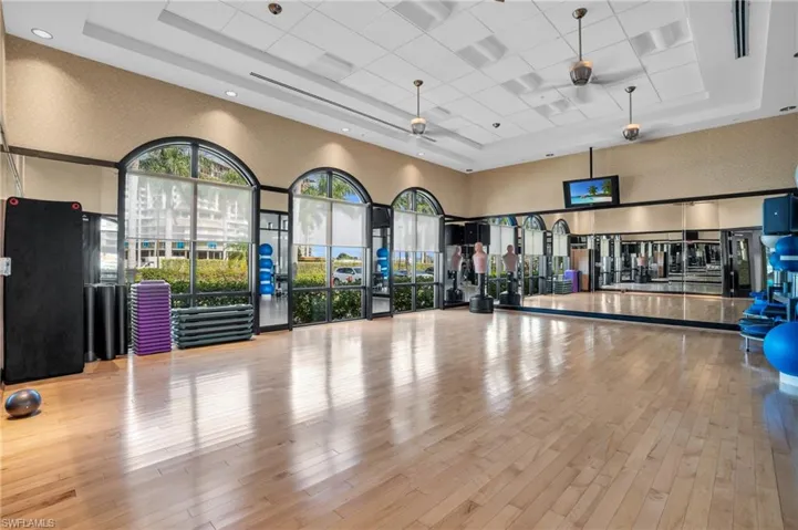 Workout area featuring a high ceiling and wallpapered walls
