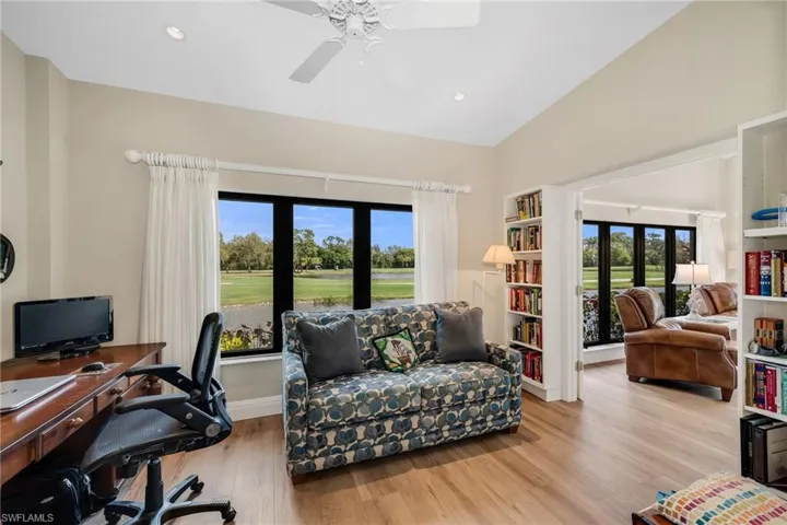 Office space featuring golf course view, ceiling fan, light wood finished floors, vaulted ceiling, and recessed lighting