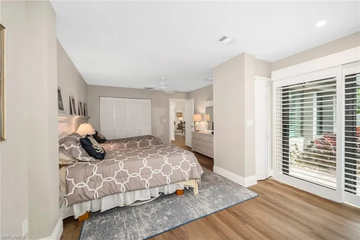 Bedroom with access to exterior, wood finished floors, a ceiling fan, and a closet