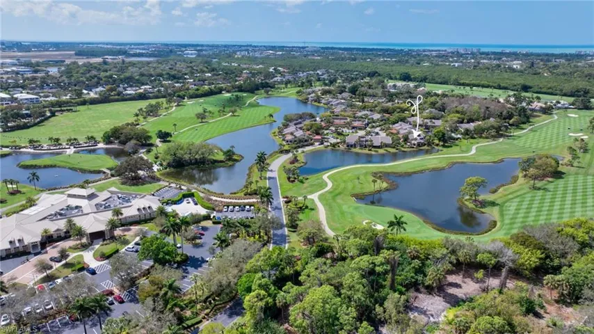 Aerial view of residential area with a large body of water and a golf club