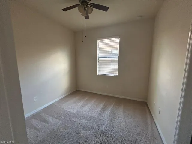 Spare room featuring light carpet and a ceiling fan