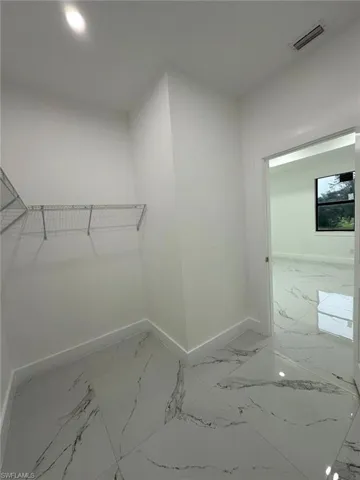 Spacious closet with light marble finish floors