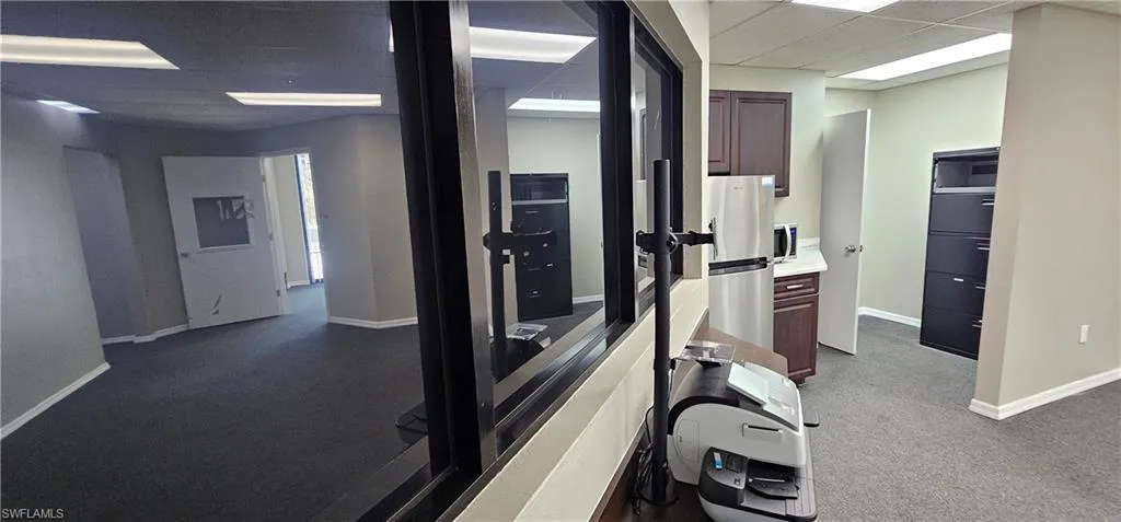 Workout room featuring a drop ceiling and dark carpet