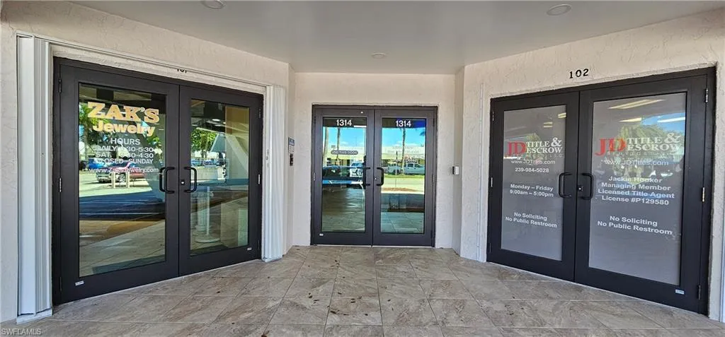 Entrance to property with french doors, stucco siding, and a water view