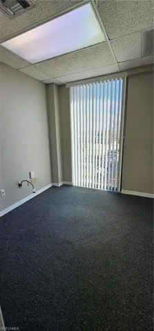 Unfurnished room featuring carpet flooring and a drop ceiling