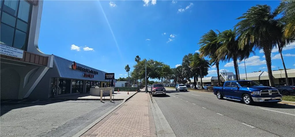 View of asphalt road featuring curbs and sidewalks