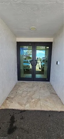 Doorway to property with french doors and stucco siding