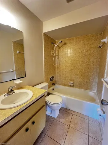 Bathroom featuring vanity, bathtub / shower combination, and light tile patterned floors
