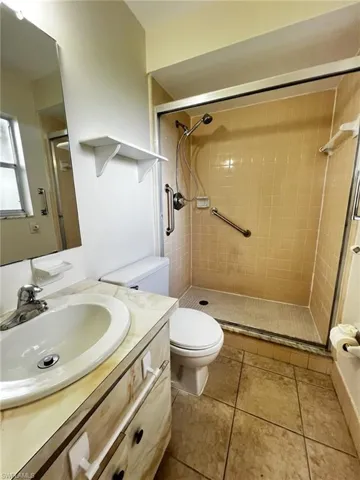 Full bathroom with vanity, a shower stall, and light tile patterned floors