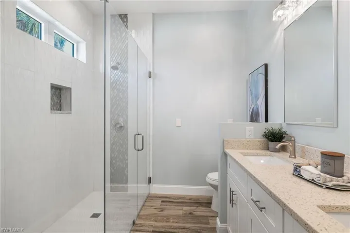 Waterfall, glass mosiac tile and seamless glass shower enclosure.  Dual sinks with separate make up area with room underneath for a vanity stool