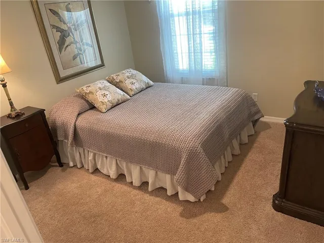 Bedroom with light carpet and baseboards